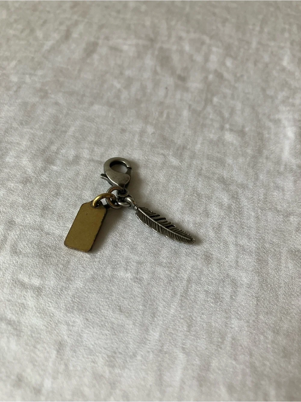 Coach: Silver Tone & Gold Tone Feather Charm Keyring